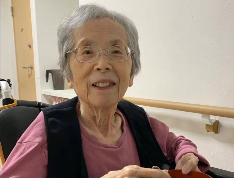 敬老会の日、笑顔で器を手にするご入居者