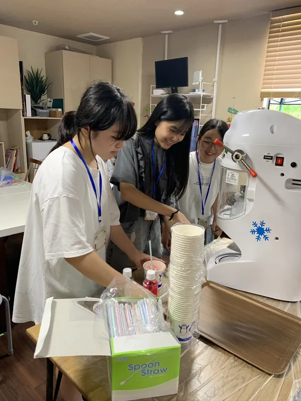 地域交流の夏祭りで、学生がかき氷を準備している様子