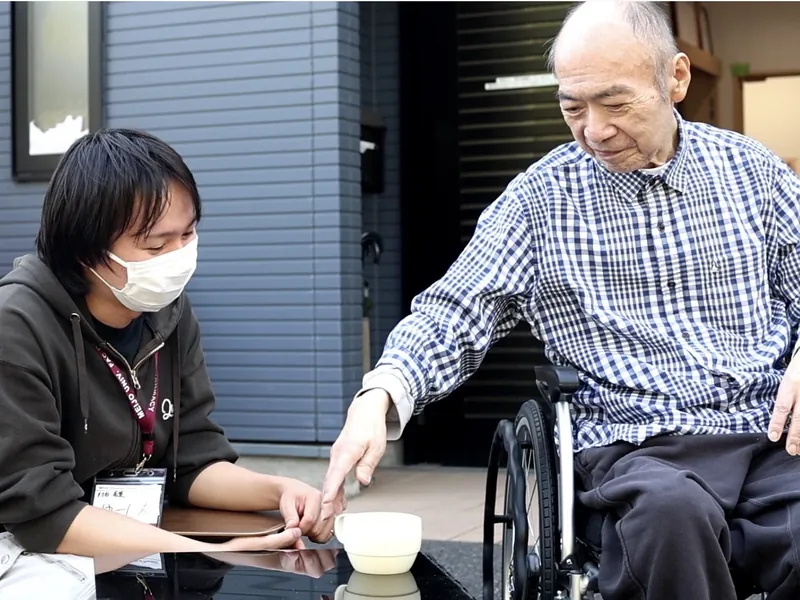 玄関先でご入居者と一緒に過ごす職員
